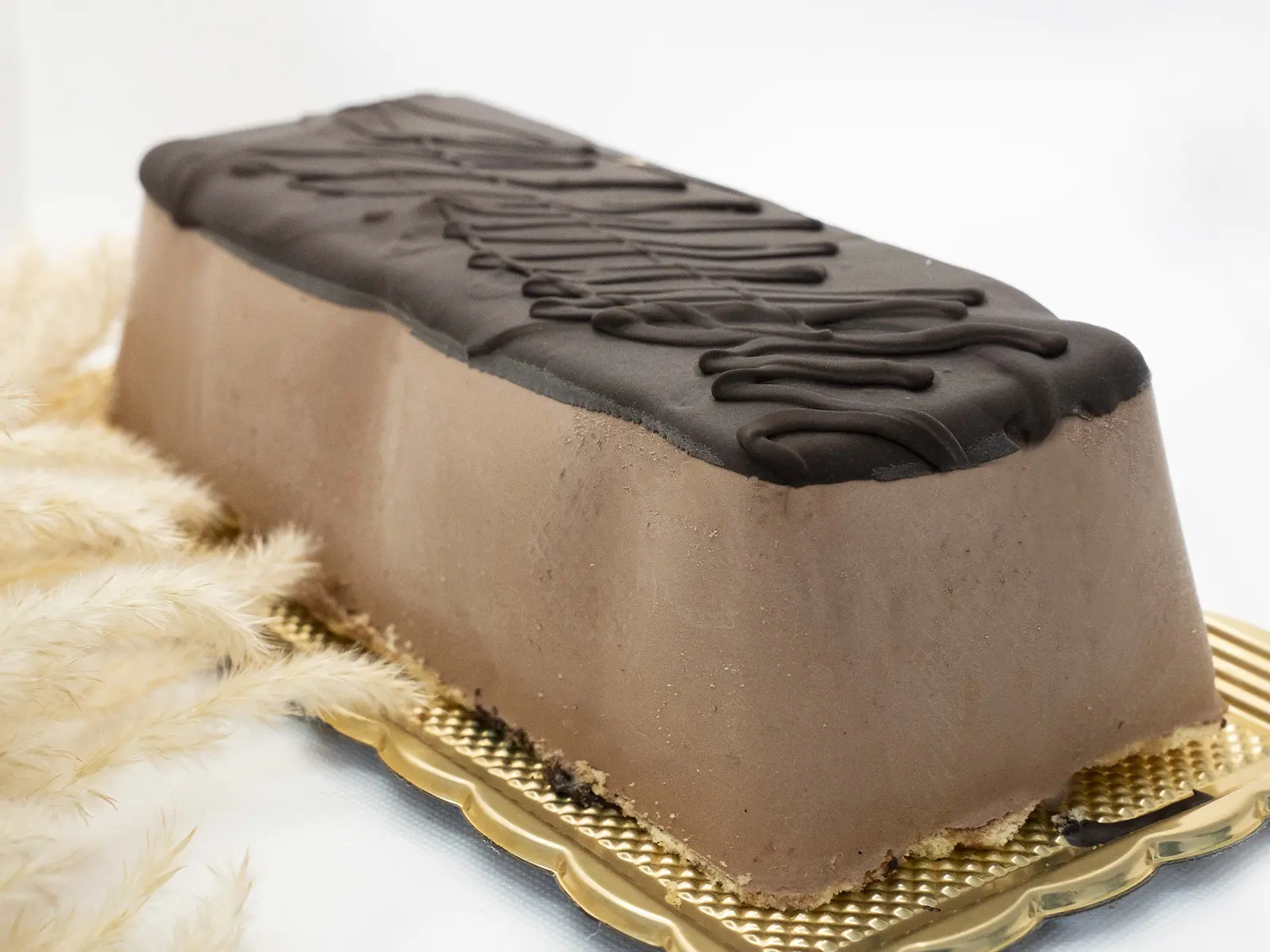Cremoso trancio di gelato alla gianduia, senza lattosio, posato su una base di soffice pan di spagna alla vaniglia e rivestito da una golosa fondente glassa al cioccolato.